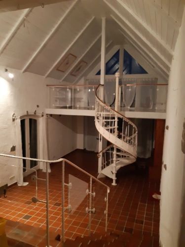 Hoher Wohnraum mit Galerie und WneltreppeeWendeltreppe